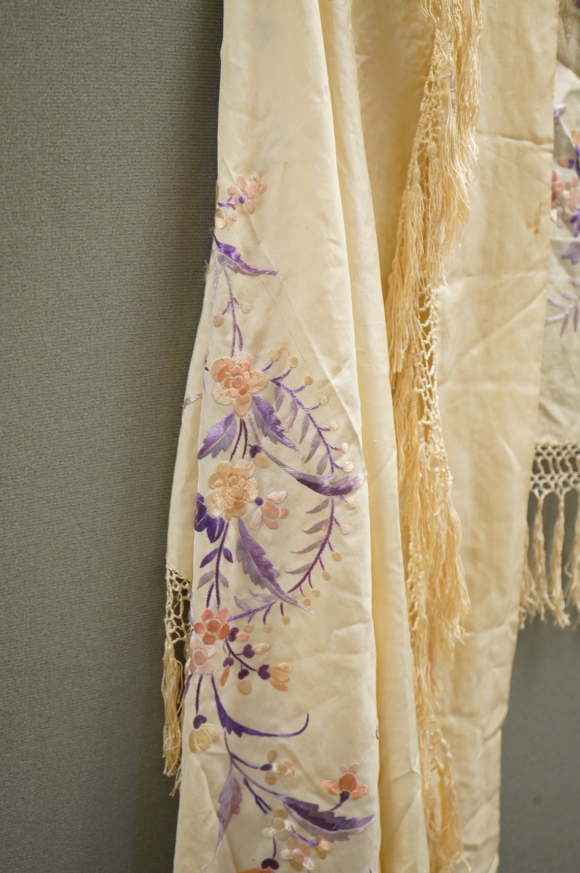 A 19th century Chinese cream silk embroidered and fringed stole, converted to a cape. Embroidered in pastel pinks and lilacs.192cm long